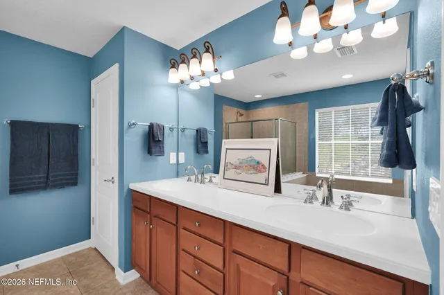 a bathroom with a sink a large mirror and a window