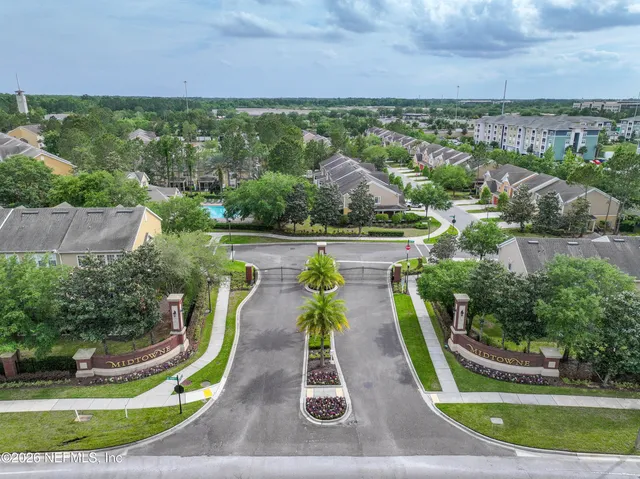 a view of a white house with a big yard and large trees