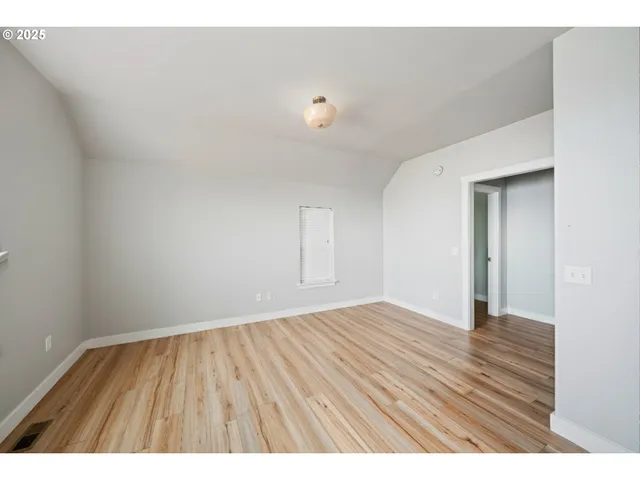 a view of an empty room and wooden floor