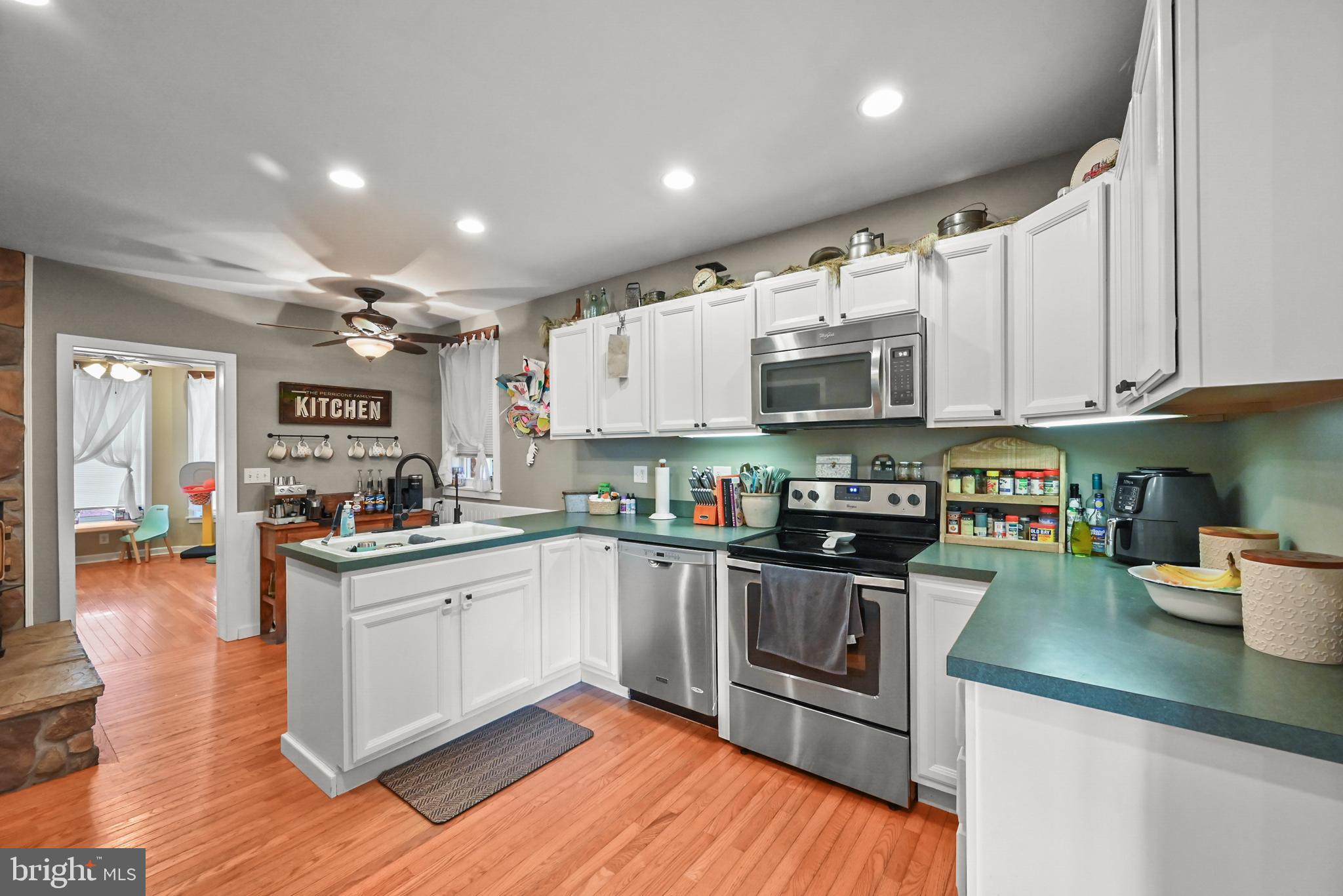 206 Ruth Avenue Hanover, PA 17331 - Photo 11 of 45 a kitchen with stainless steel appliances granite countertop a refrigerator a stove top oven a sink dishwasher and white cabinets with wooden floor