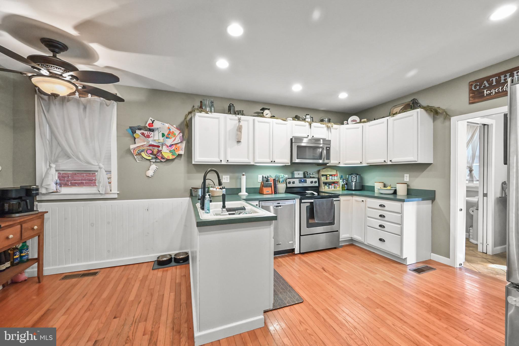 206 Ruth Avenue Hanover, PA 17331 - Photo 12 of 45 a kitchen with granite countertop a refrigerator oven a sink dishwasher and white cabinets with wooden floor