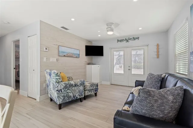a dining room with wooden floor a chandelier a glass table and chairs