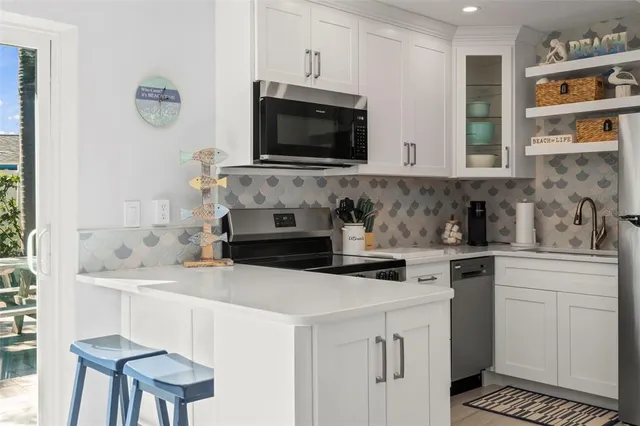 a kitchen with stainless steel appliances granite countertop a stove a refrigerator and a stove