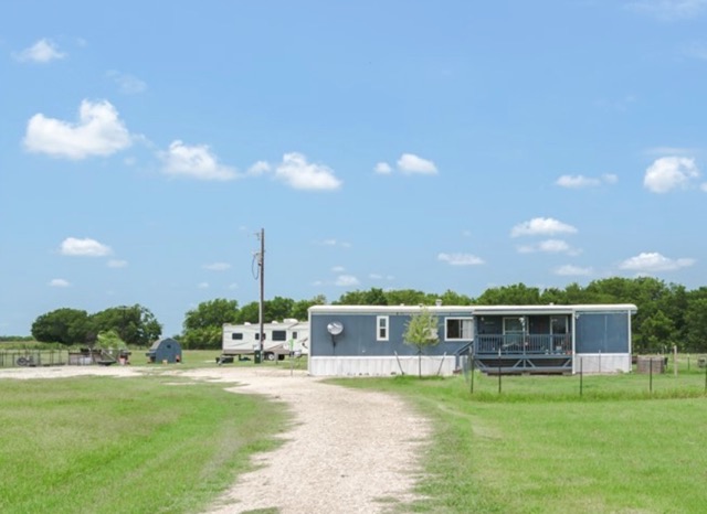 835 County Road 182 Marlin, TX 76661 - Photo 1 of 27 a front view of a house with a garden