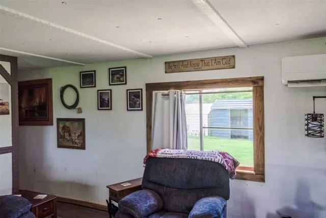 a living room with furniture a bookshelf and a window
