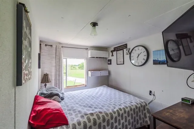 a bedroom with a bed and a flat screen tv