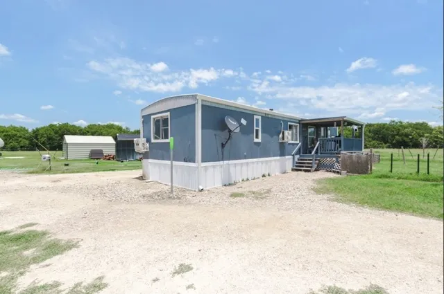 a view of house with a backyard