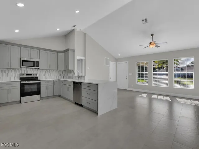 a kitchen with stainless steel appliances kitchen island wooden cabinets and a refrigerator