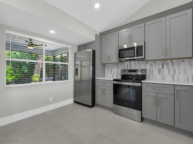 a kitchen with stainless steel appliances granite countertop a refrigerator a stove a sink and a microwave