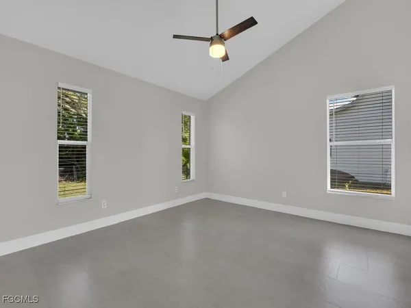 an empty room with windows and fan