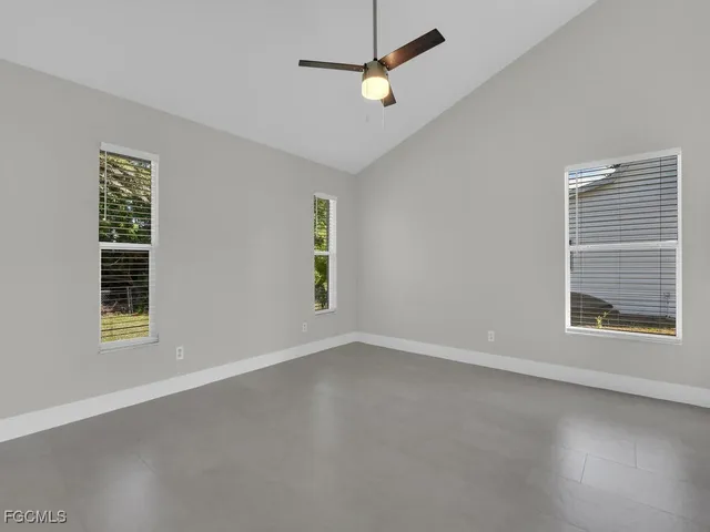 an empty room with windows and fan