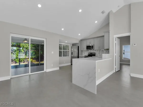 a view of a kitchen with refrigerator and windows