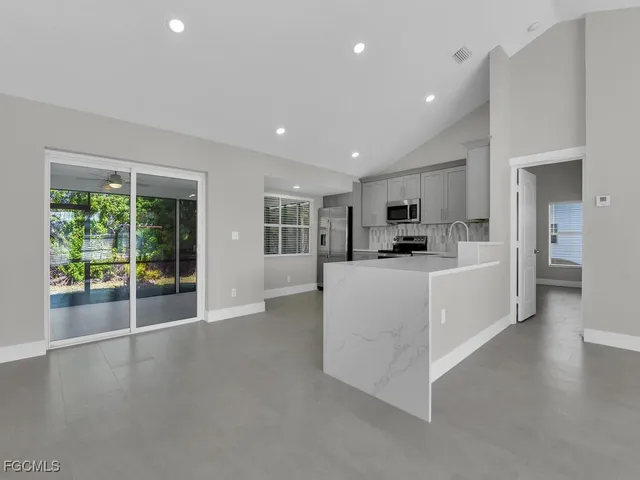 a view of a kitchen with refrigerator and windows
