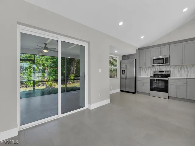 a view of a kitchen with refrigerator and a sink
