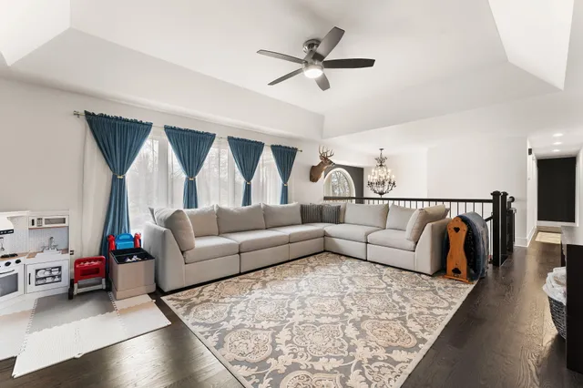 a living room with furniture flat screen tv and wooden floor