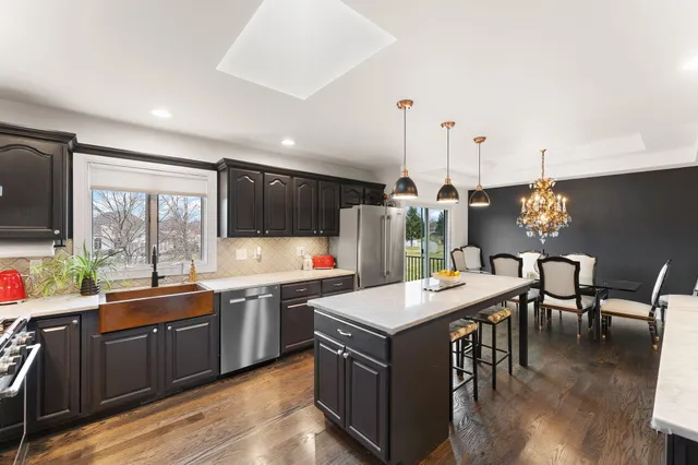 a kitchen with stainless steel appliances kitchen island granite countertop a sink a stove and cabinets