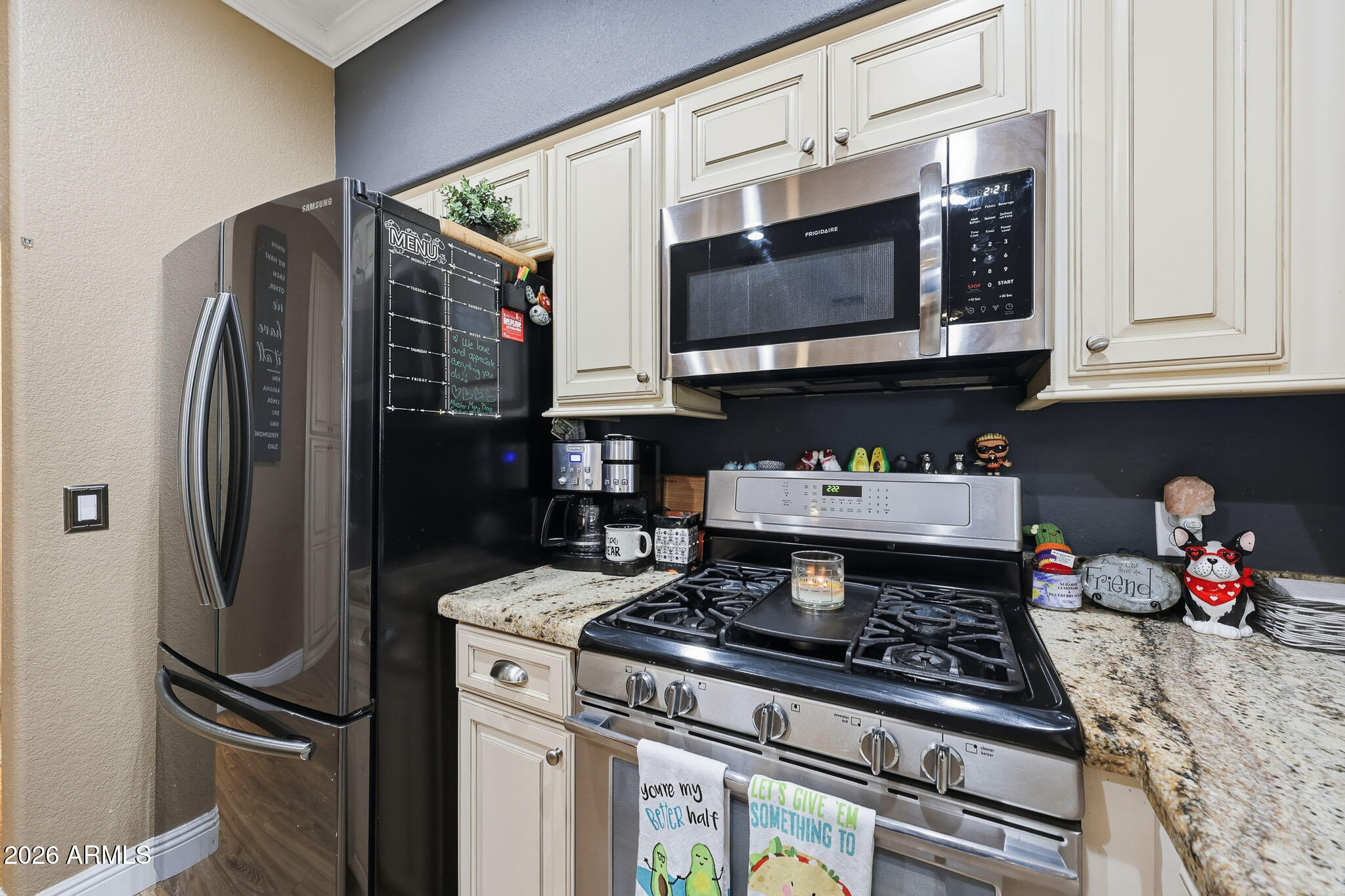 16248 West Hadley Street Goodyear, AZ 85338 - Photo 12 of 55 a kitchen with stainless steel appliances granite countertop a stove refrigerator and a microwave
