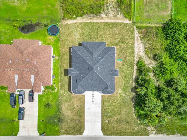 an aerial view of a house with a yard basket ball court and outdoor seating
