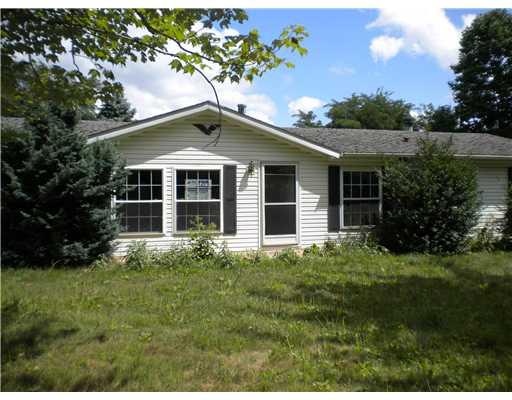 Exterior Front. Level front yard with mature shrubs