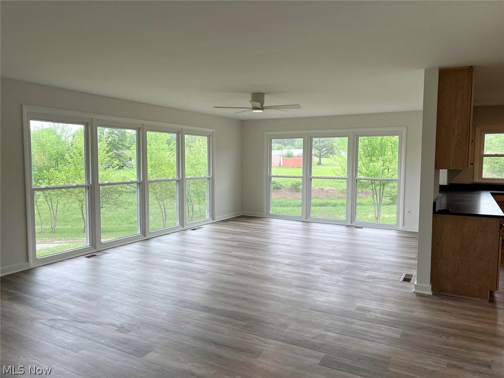 550 Johnson Road Wadsworth, OH 44281 - Photo 7 of 40 Unfurnished living room featuring wood-type flooring, plenty of natural light, and ceiling fan