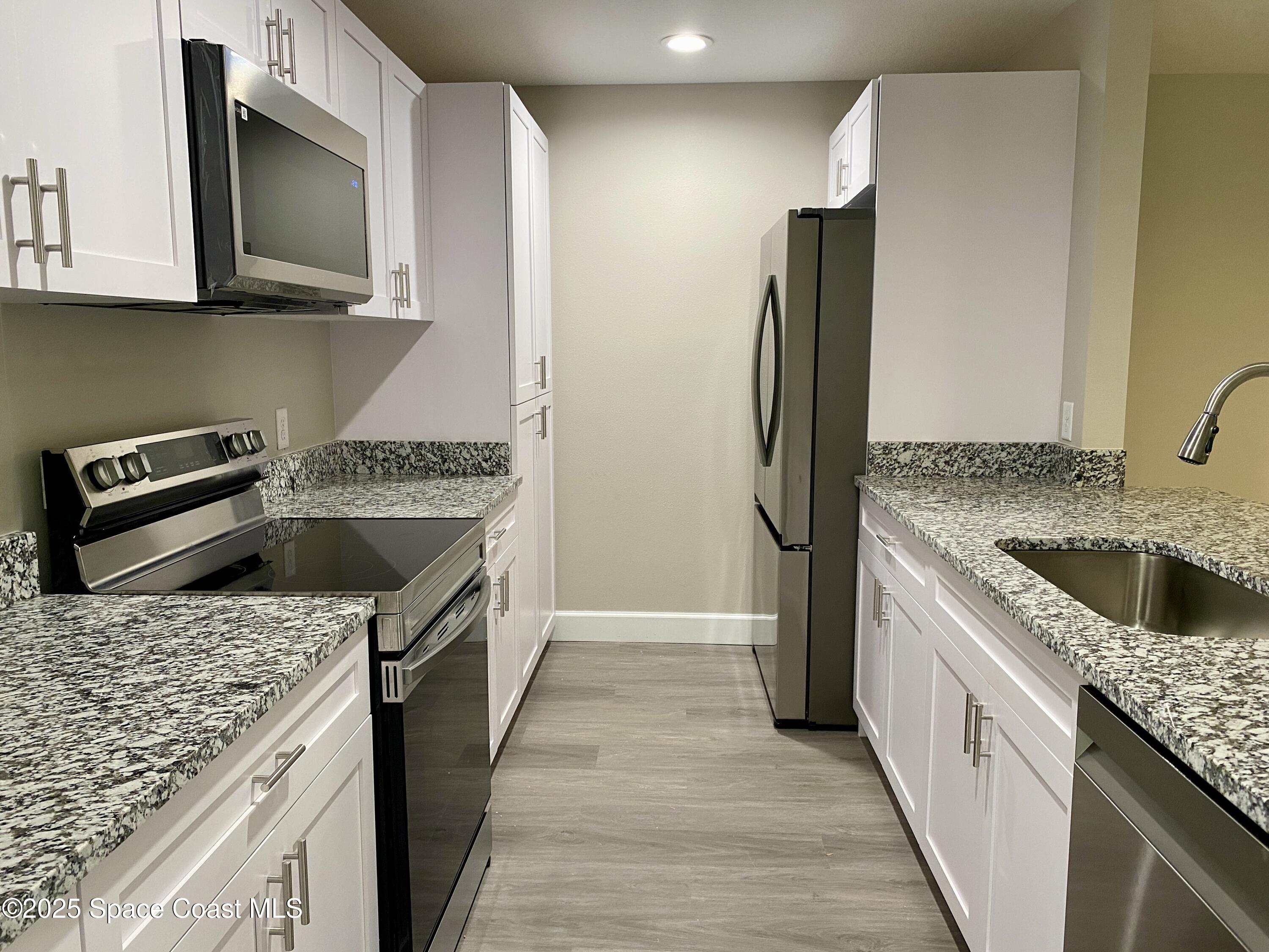 6005 Sisson Road Titusville, FL 32780 - Photo 2 of 16 a kitchen with a sink stove and refrigerator