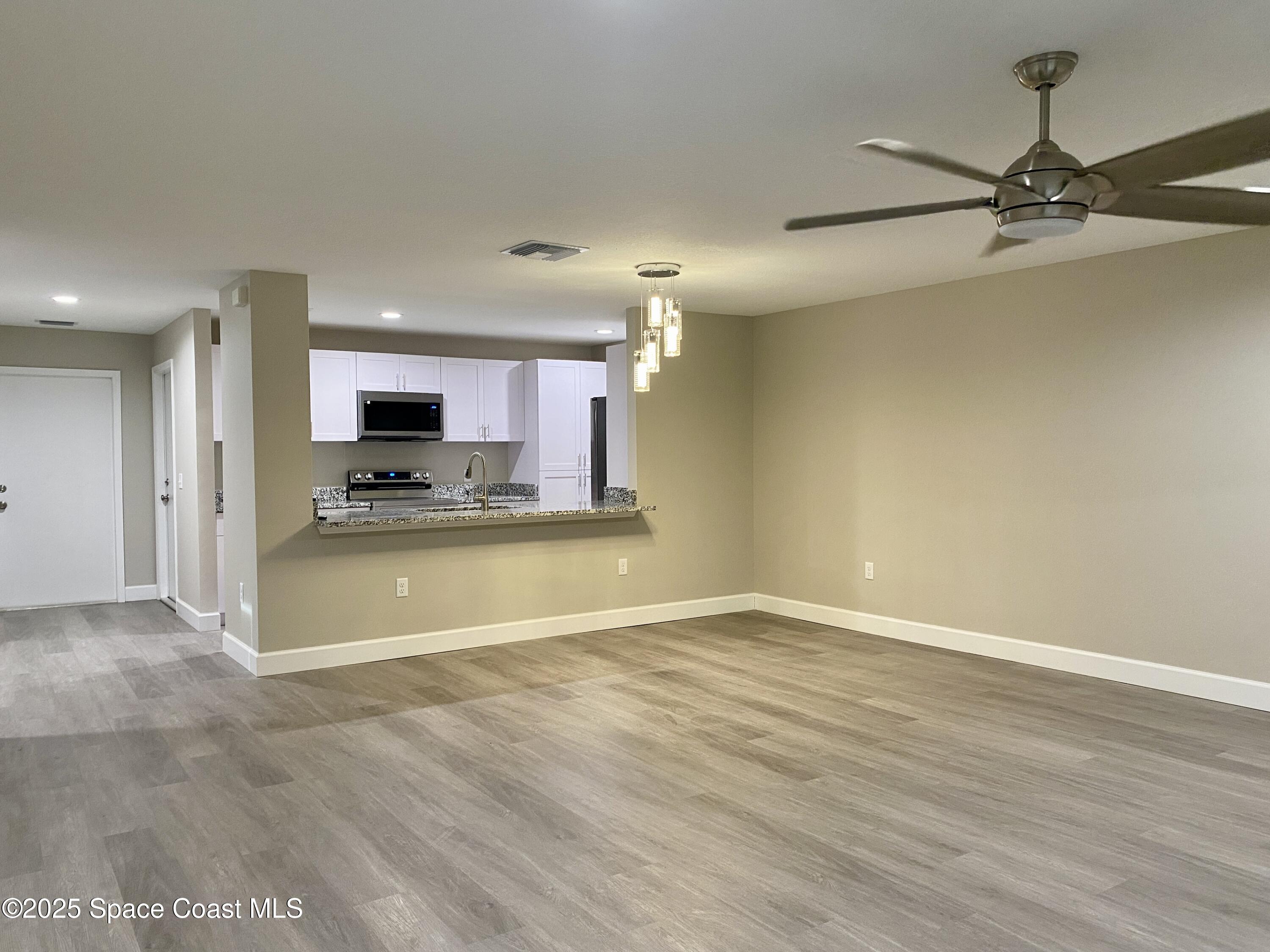 6005 Sisson Road Titusville, FL 32780 - Photo 3 of 16 a view of kitchen with microwave and stove