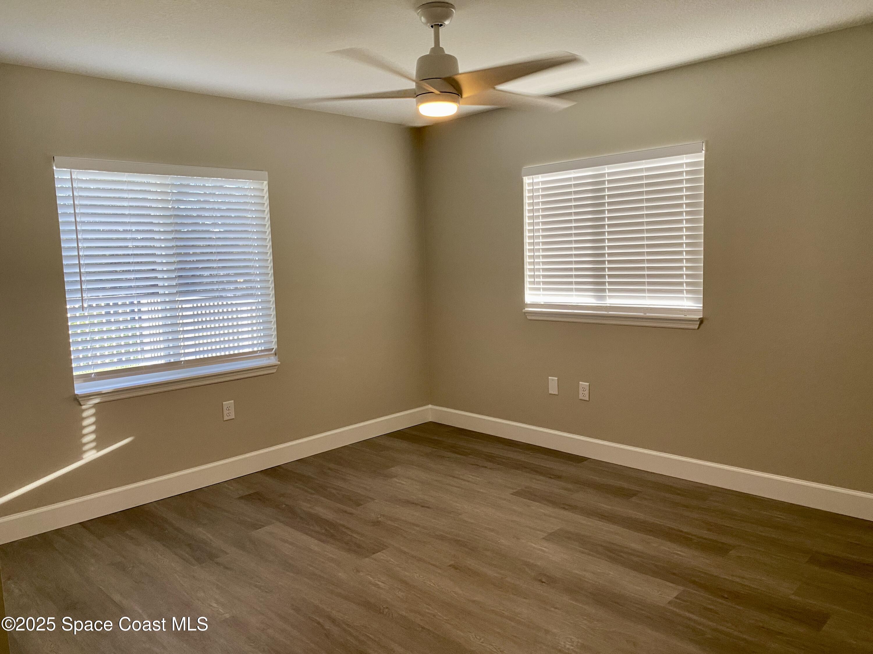 6005 Sisson Road Titusville, FL 32780 - Photo 6 of 16 a view of an empty room with wooden floor and a window
