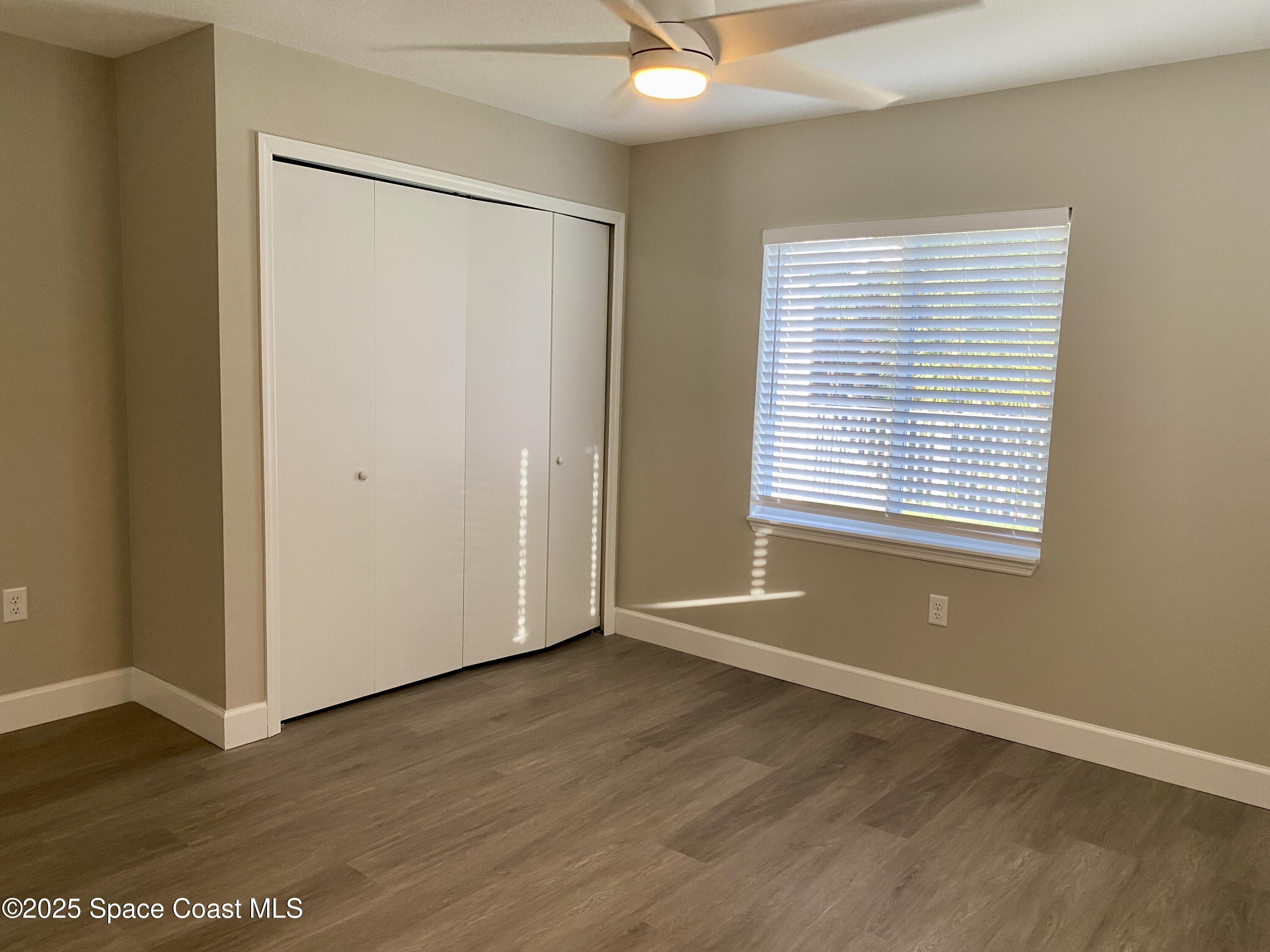 6005 Sisson Road Titusville, FL 32780 - Photo 8 of 16 a view of an empty room with wooden floor and a window