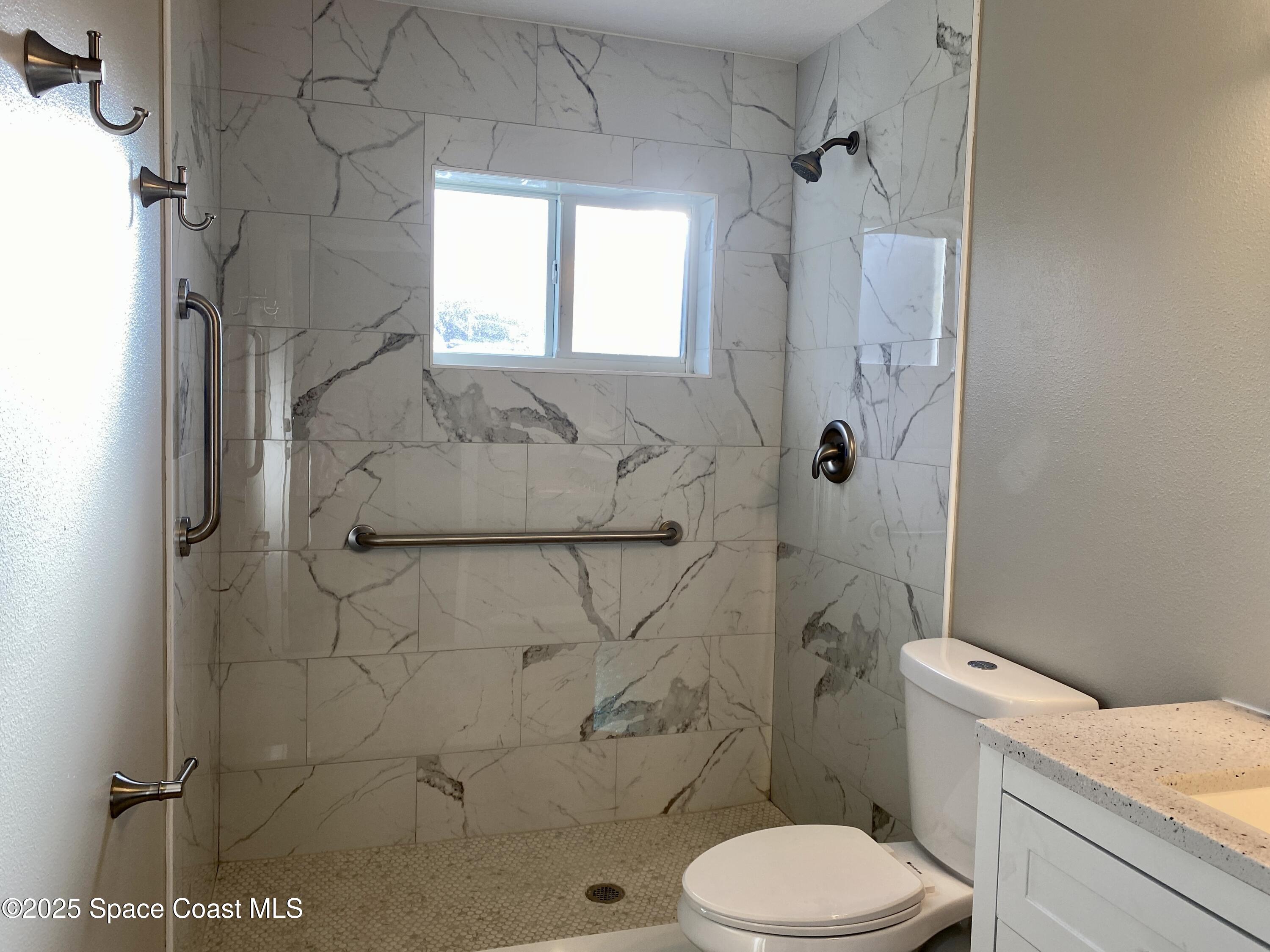 6005 Sisson Road Titusville, FL 32780 - Photo 9 of 16 a white toilet sitting next to a bath tub shower