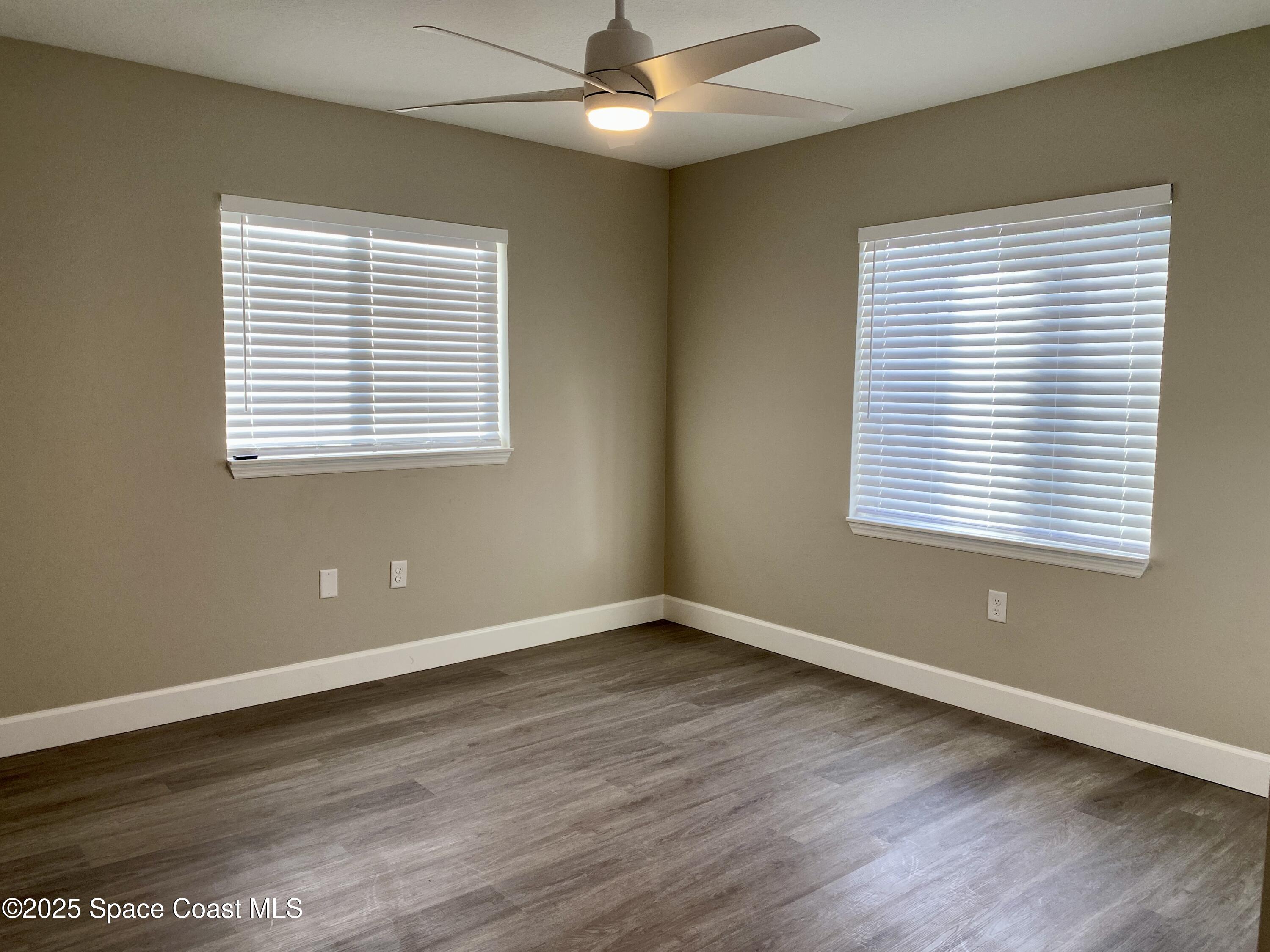 6005 Sisson Road Titusville, FL 32780 - Photo 10 of 16 a view of an empty room with wooden floor and a window