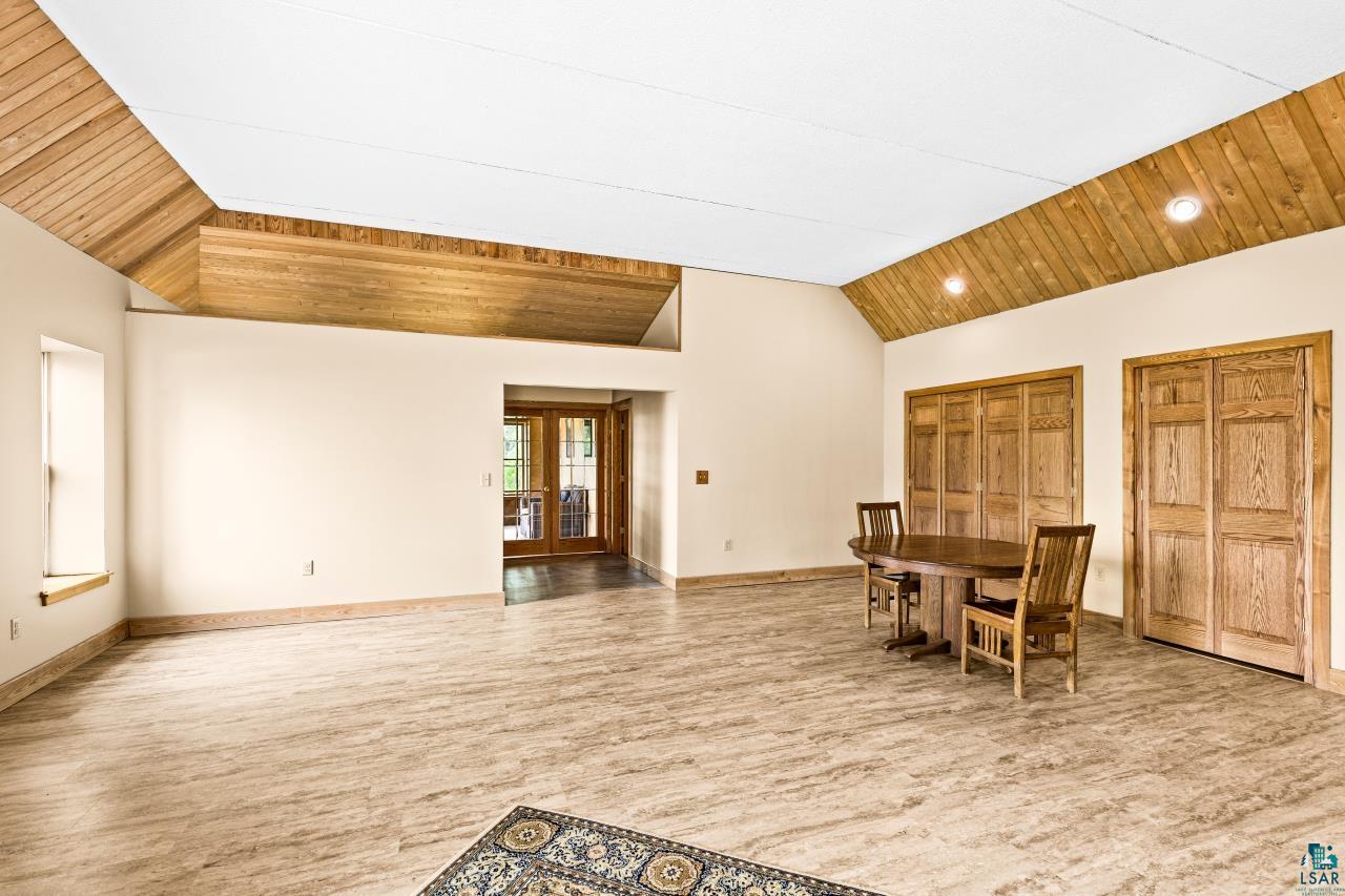 4800 Tower Road Moose Lake, MN 55767 - Photo 10 of 83 Spacious interior featuring a vaulted ceiling with exposed wood-finish beams, light-toned wall finishes, and wood-look flooring