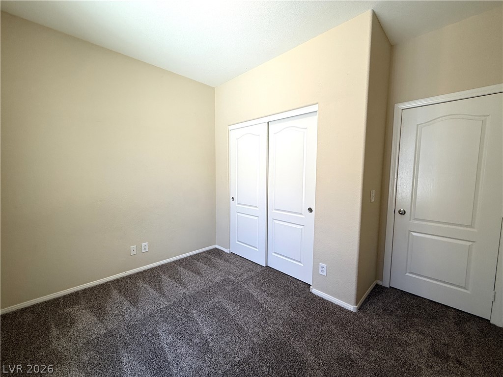 5942 Rampolla Drive Las Vegas, NV 89141 - Photo 18 of 27 A well-maintained bedroom offers practical sliding closet doors and plush carpet flooring.