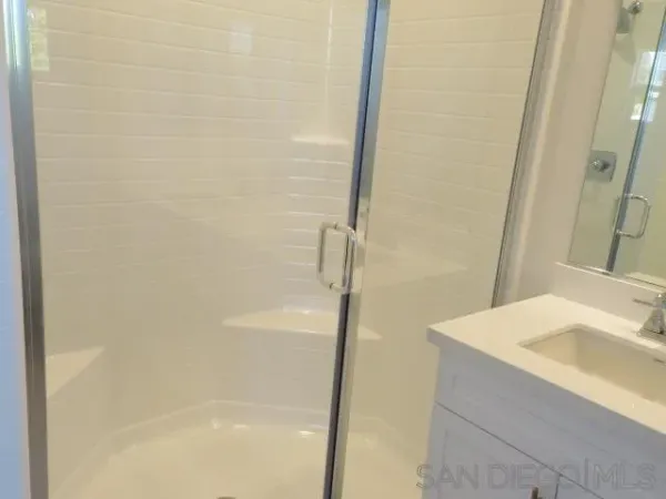 a bathroom with a granite countertop sink toilet and mirror