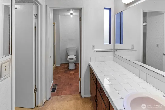 a bathroom with a sink a toilet and a mirror