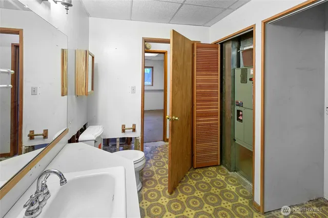 a bathroom with a sink a toilet and mirror