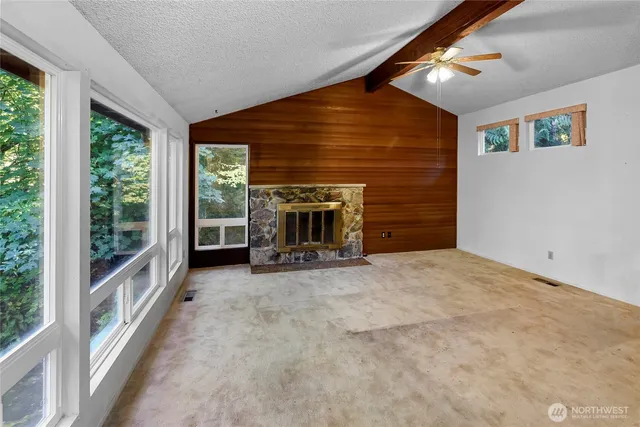 a view of empty room with fireplace and fan