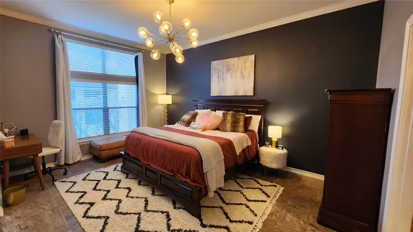 a bedroom with a bed and a chandelier