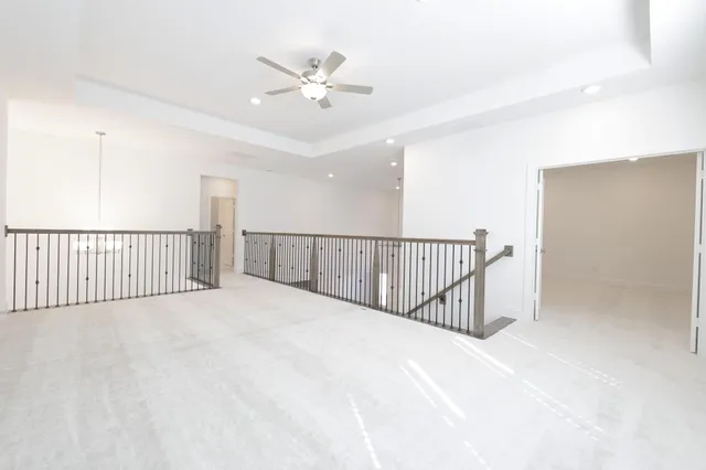 a view of a hallway with a chandelier fan