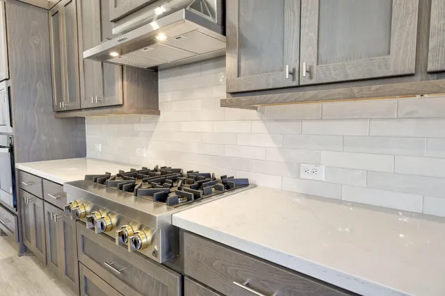 a kitchen with stainless steel appliances granite countertop a stove and a refrigerator
