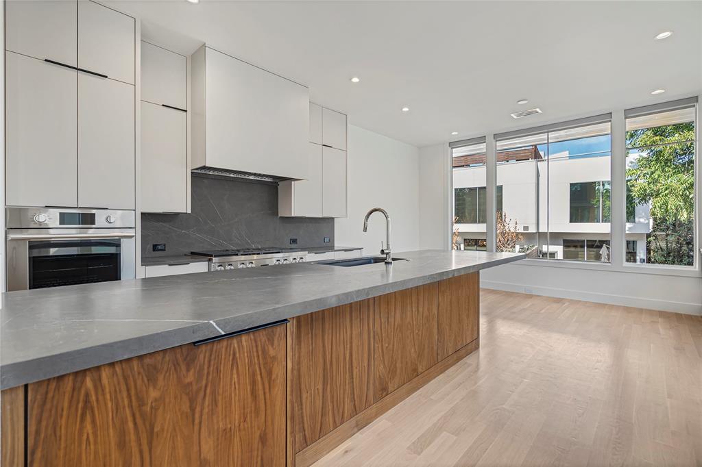 3619 Springbrook Street Dallas, TX 75205 - Photo 13 of 35 a large kitchen with granite countertop a sink and a stove top oven with wooden floor