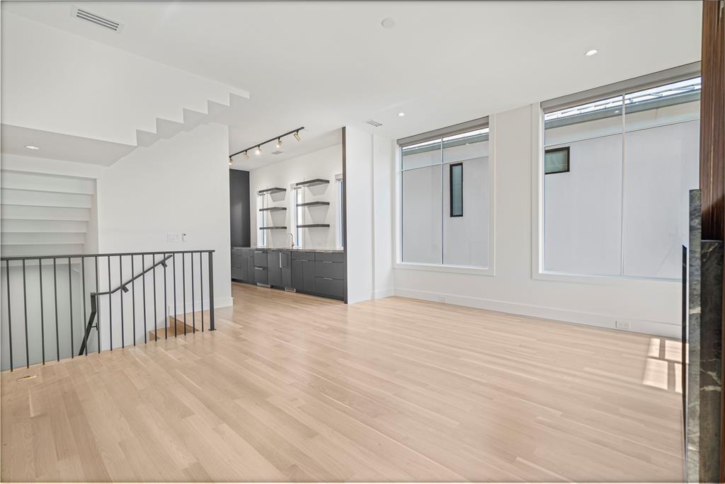 3619 Springbrook Street Dallas, TX 75205 - Photo 10 of 35 a view of an empty room with wooden floor and kitchen view