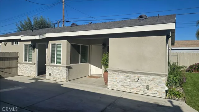 a front view of a house with basket ball court and potted plants