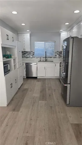 a kitchen with stainless steel appliances a refrigerator sink and cabinets