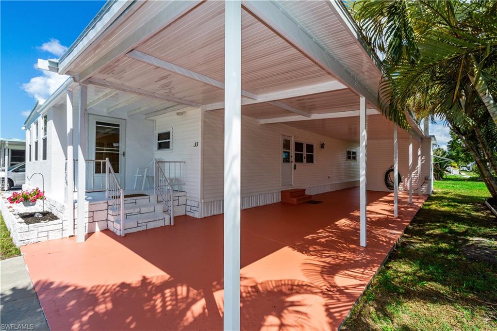 33 Henderson Drive Naples, FL 34114 - Photo 2 of 15 a view of a patio with dining table and chairs with couches and wooden fence