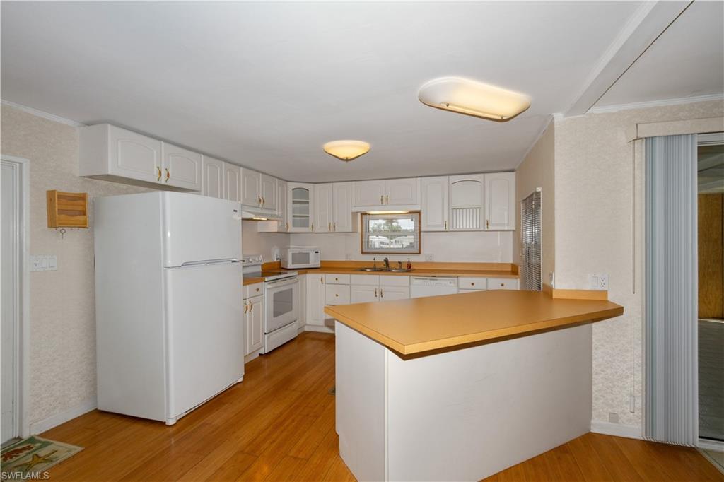 33 Henderson Drive Naples, FL 34114 - Photo 4 of 15 a view of a kitchen with wooden floor and electronic appliances