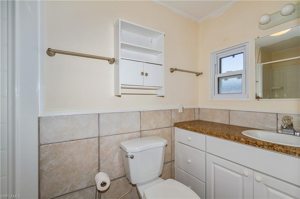 33 Henderson Drive Naples, FL 34114 - Photo 9 of 15 a bathroom with a granite countertop sink mirror vanity and toilet