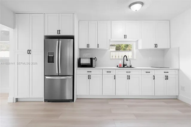 a kitchen with white cabinets and stainless steel appliances