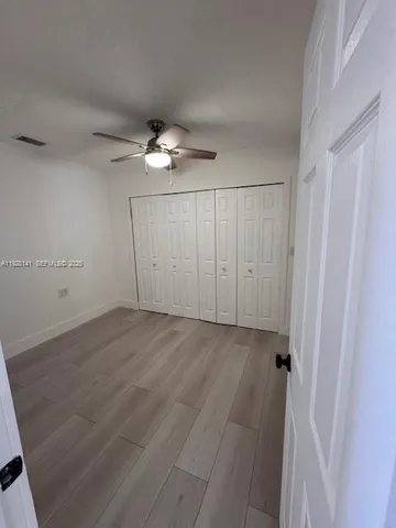 an empty room with a ceiling fan and a window