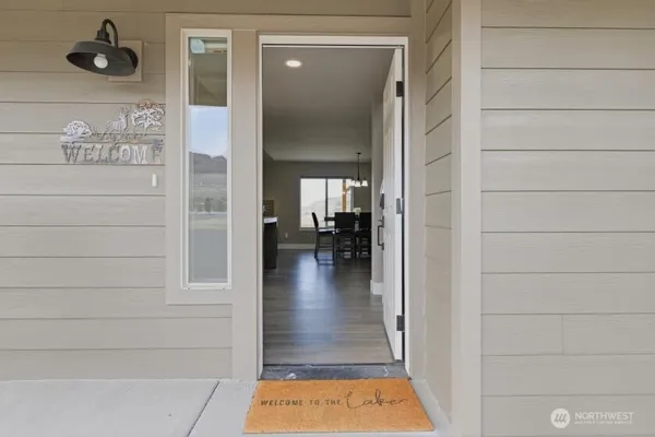 a view of a hallway with wooden floor and a living room