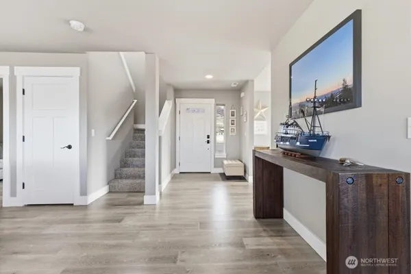 a view of a hallway with wooden floor and staircase